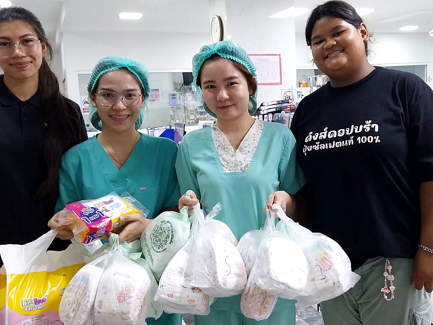 อาสาสมัคร Hand to Hand และเจ้าหน้าที่โรงพยาบาลพร้อมผ้าอ้อมและของใช้เด็กที่บริจาคให้ครอบครัวในแผนกสูติกรรม